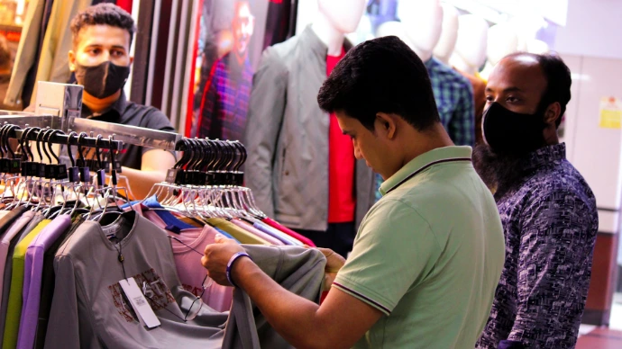 a man looking at a shirt on a rack in a store